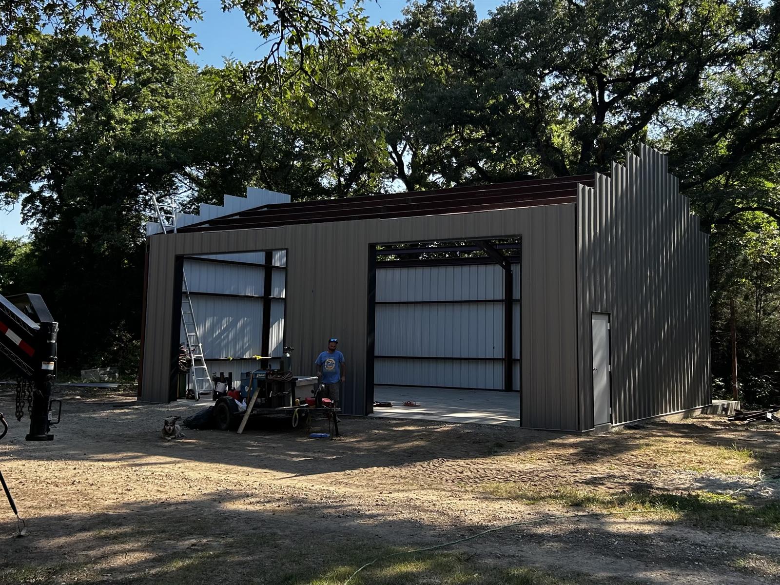 Metal shop building erected by Zion Fabrication — wall panels and roof framing going up on a steel structure